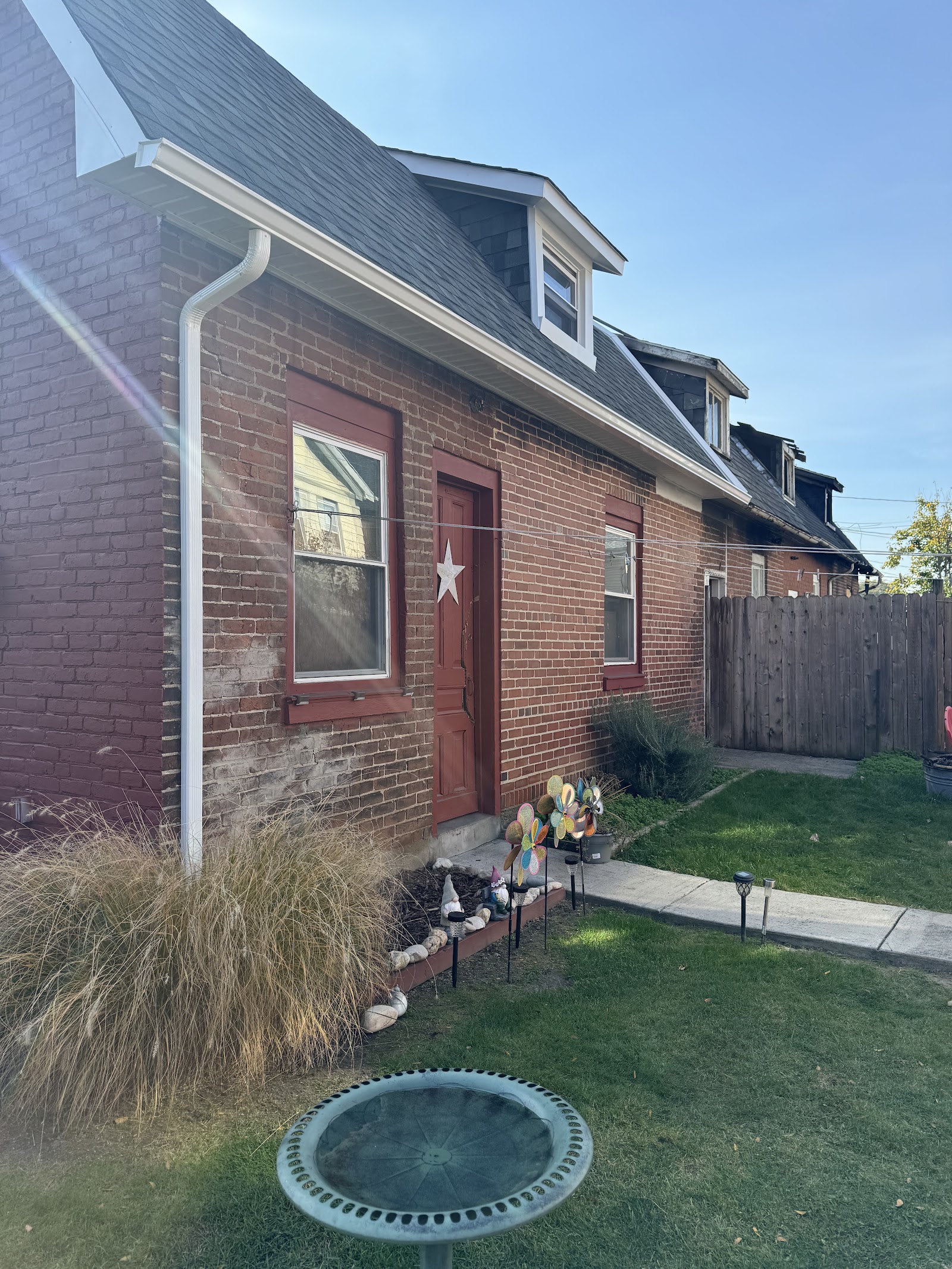 White seamless gutter and downspout installed on a brick home