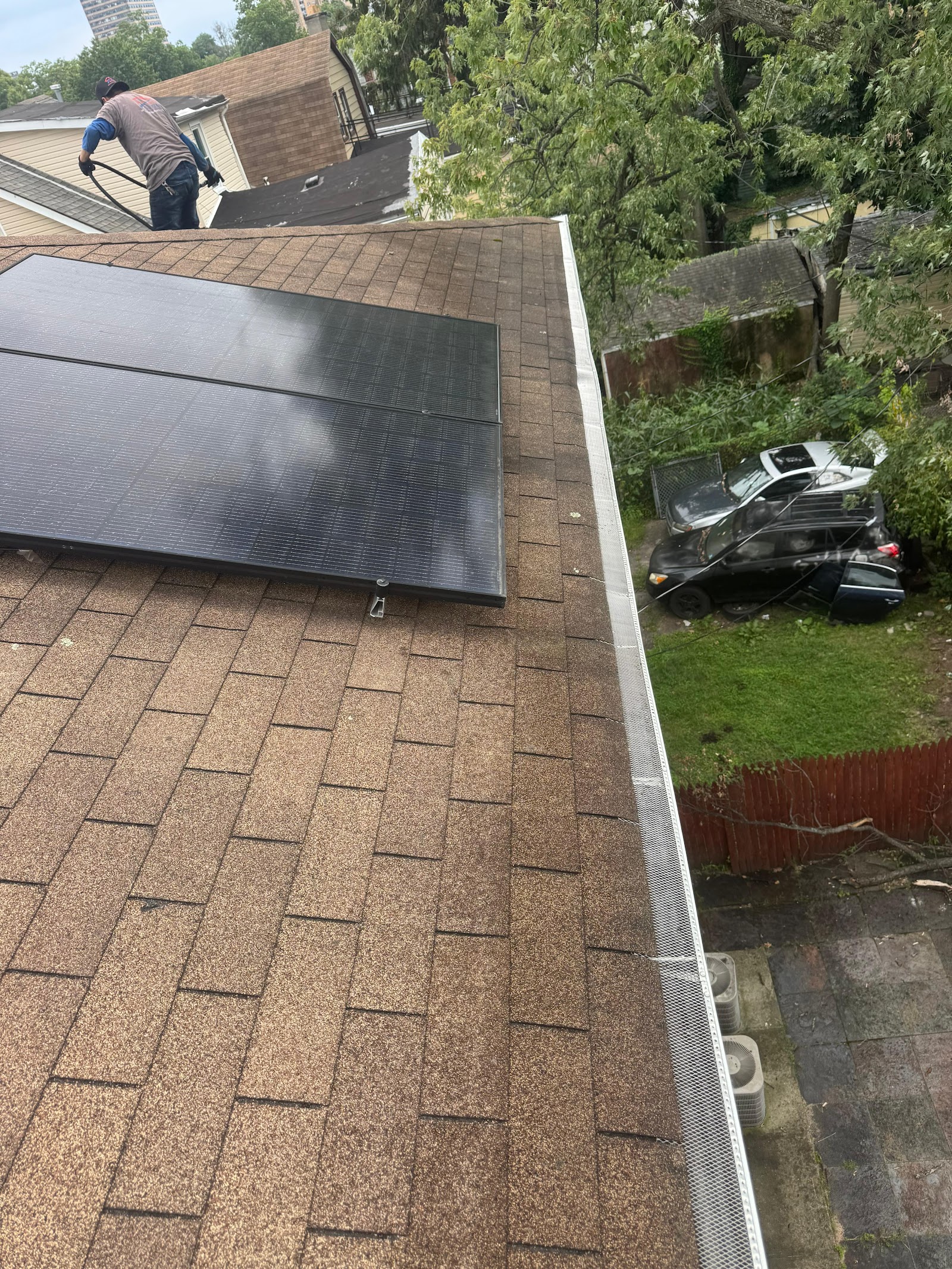 Solid gutter guard panels laid along a shingle roof edge
