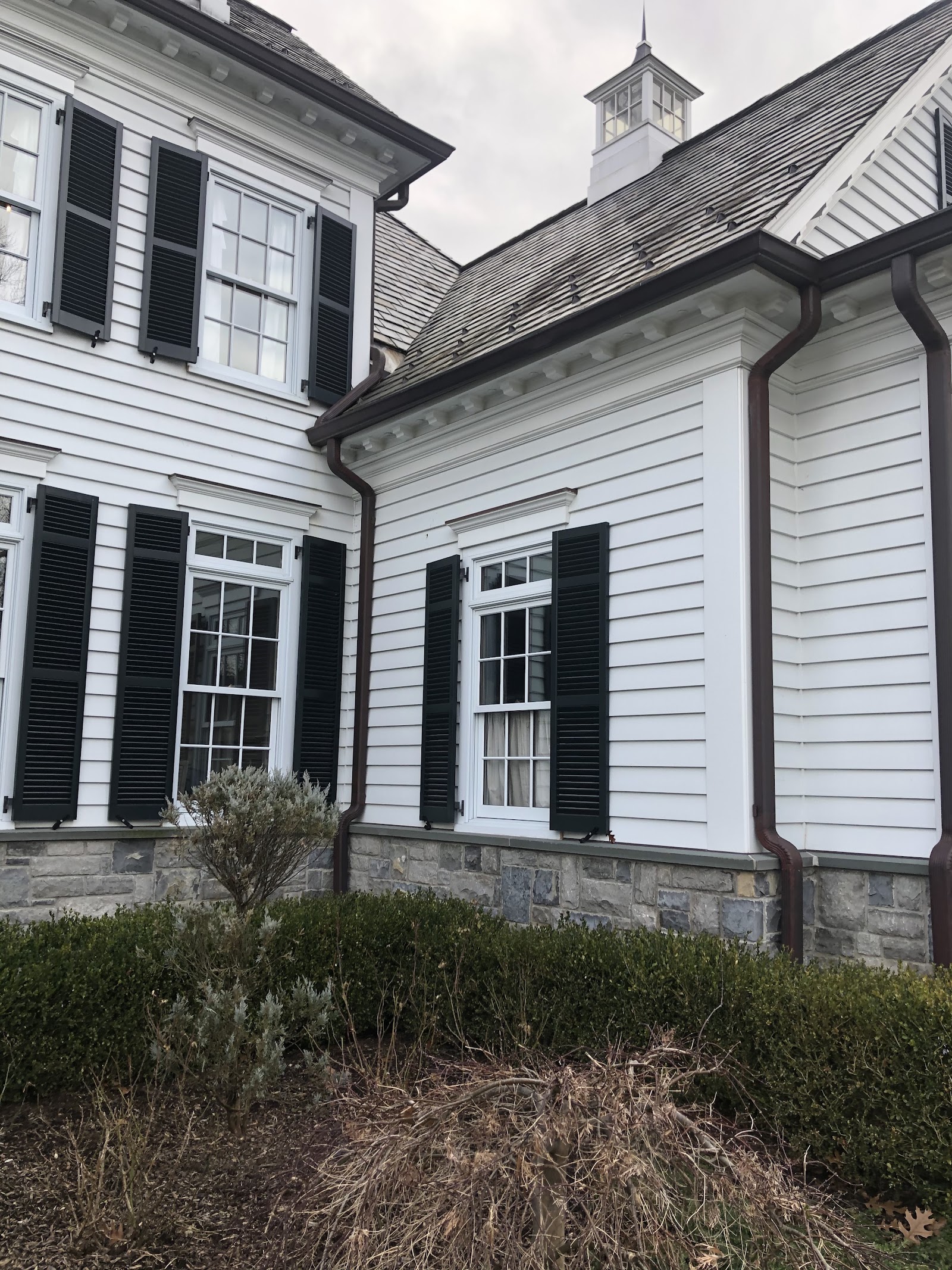 White colonial home with clean gutters along the front roofline