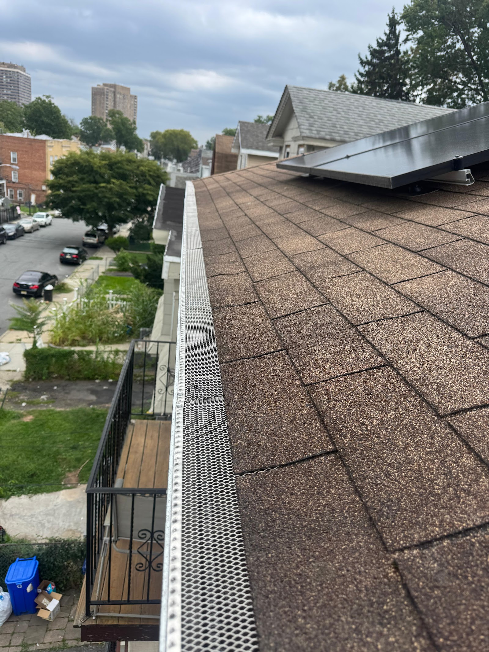 Gutter guard running the full length of a roofline above a street