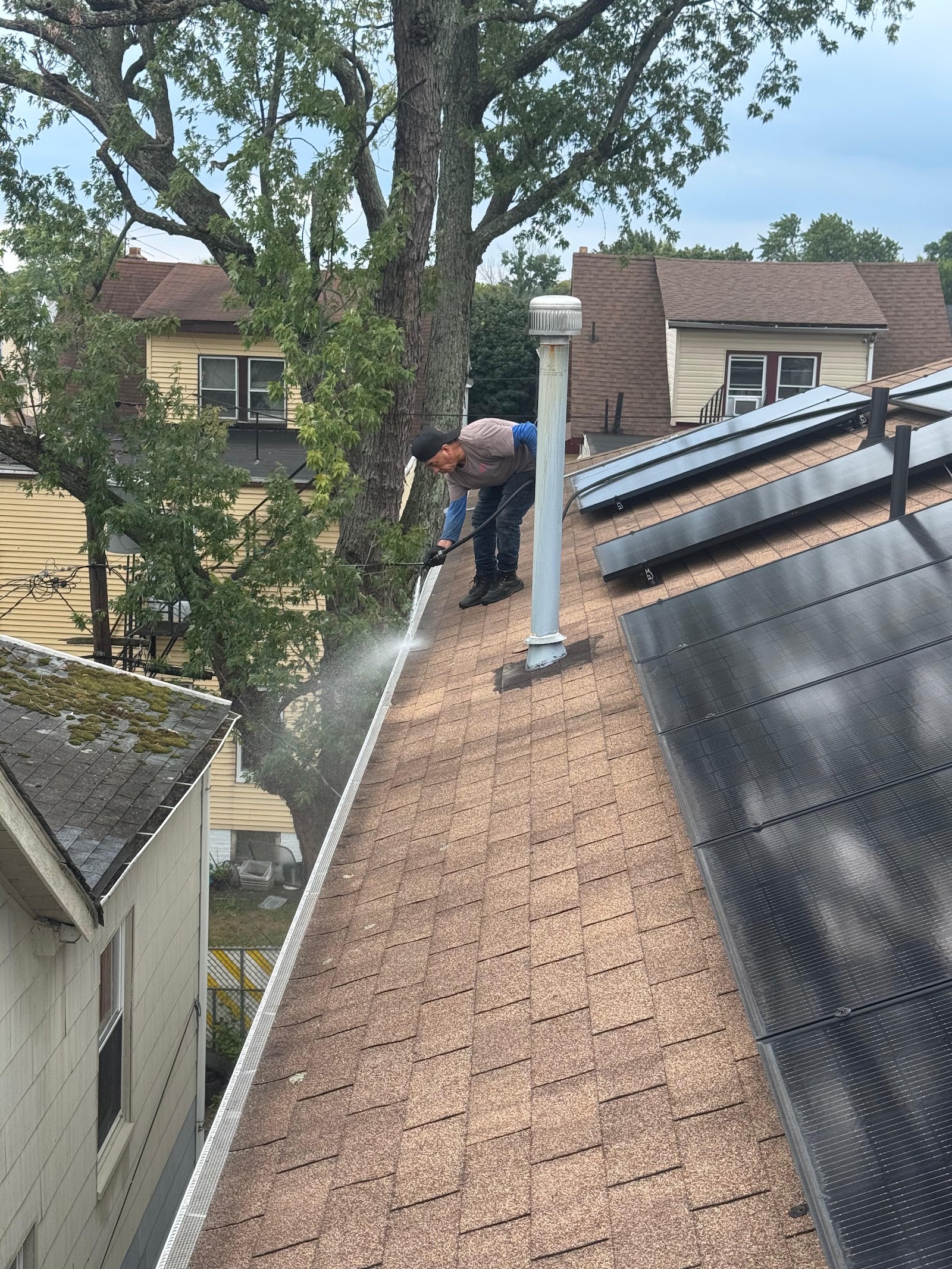 Crew installing gutter guard panels along a roofline