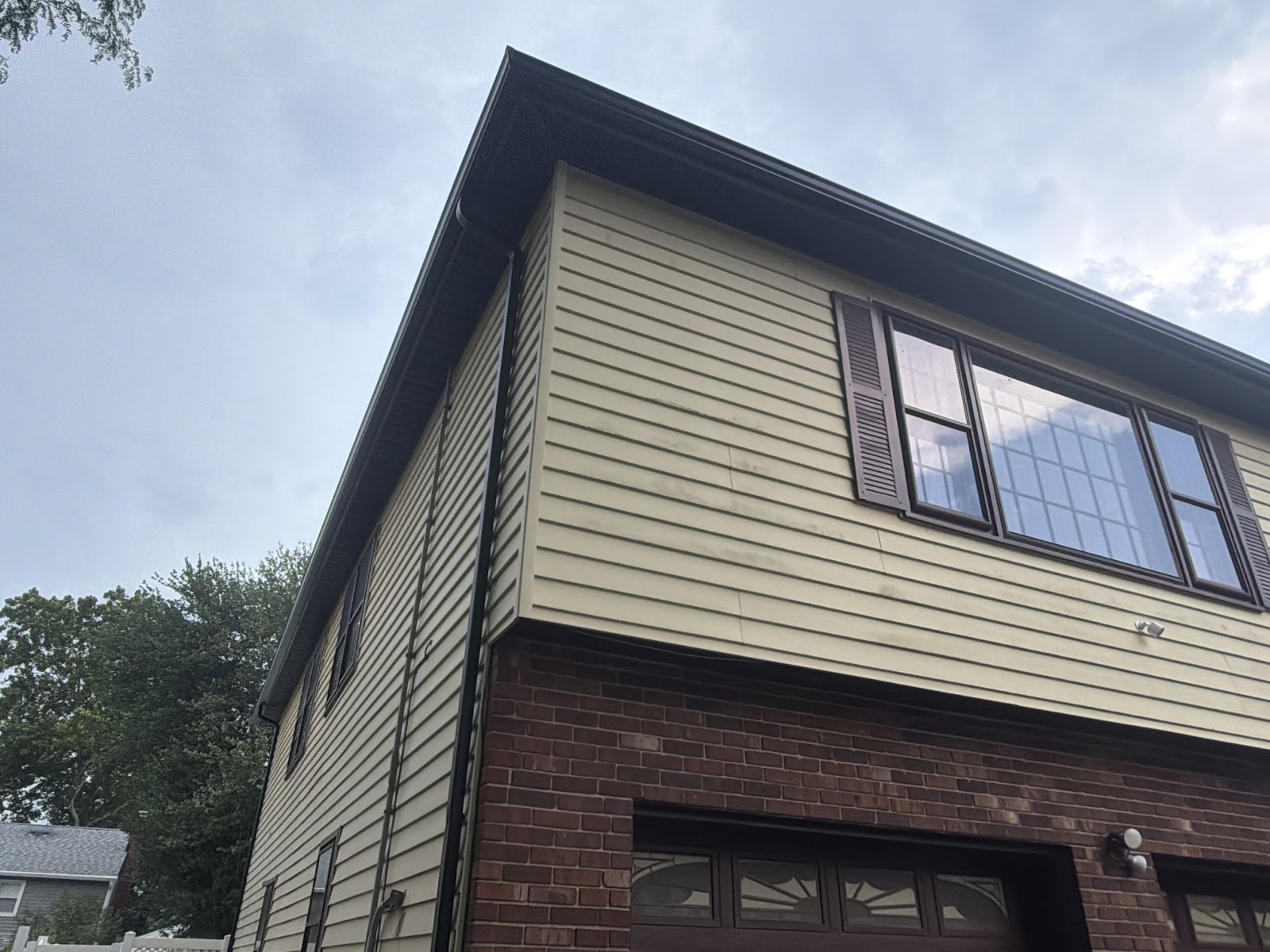 Two-story home exterior after gutter work