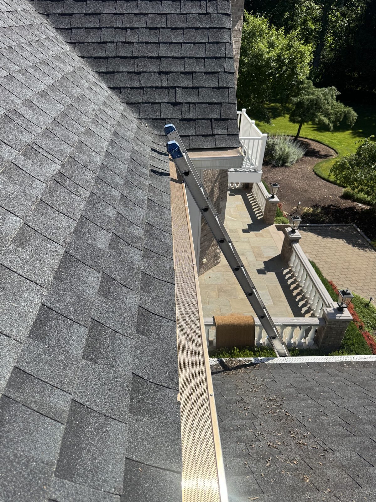 Technician clearing leaves from a residential gutter in New Jersey