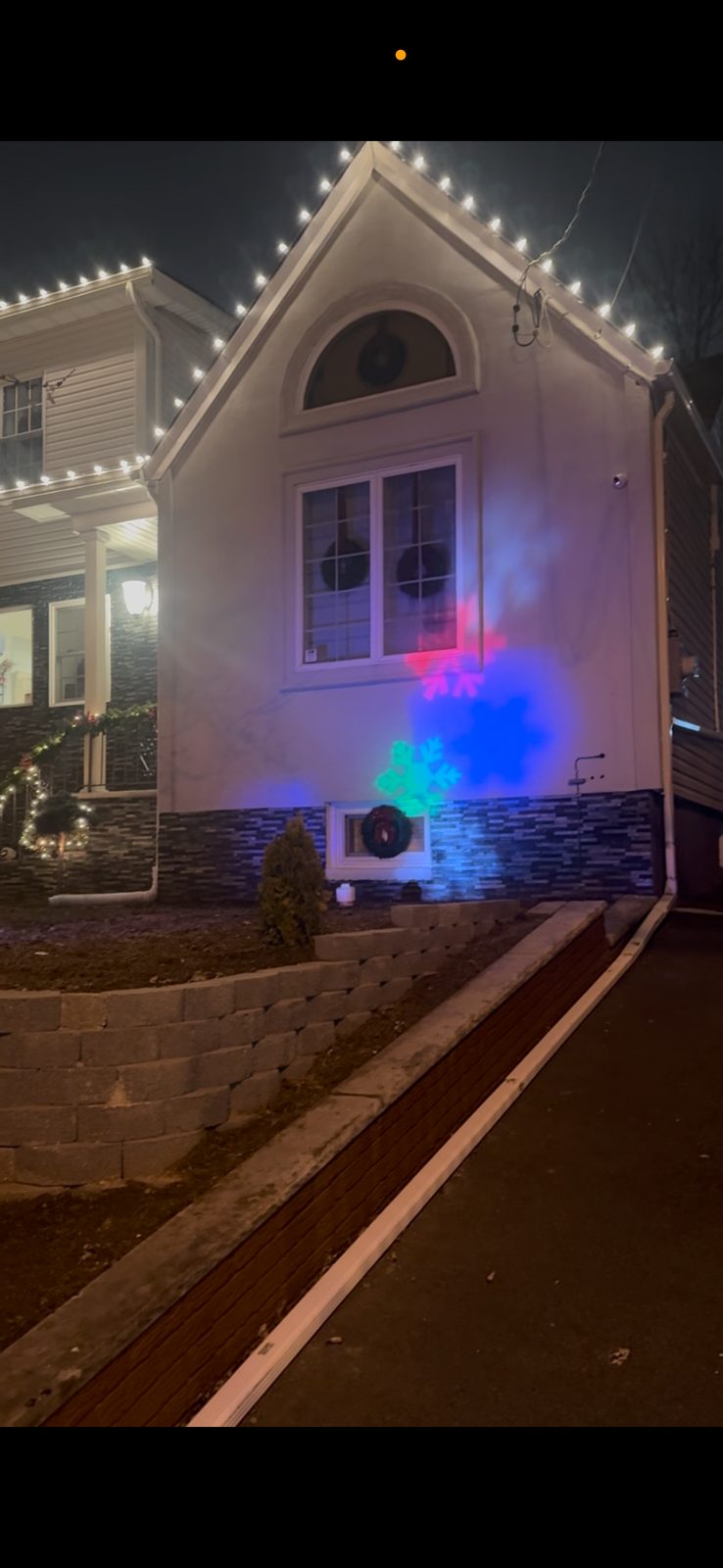 Home with holiday lights installed neatly along the roofline at dusk